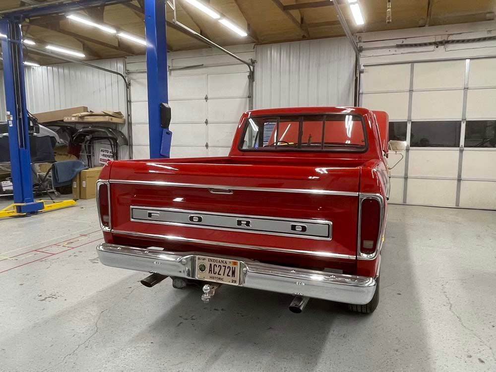 A red ford truck is parked in a garage.