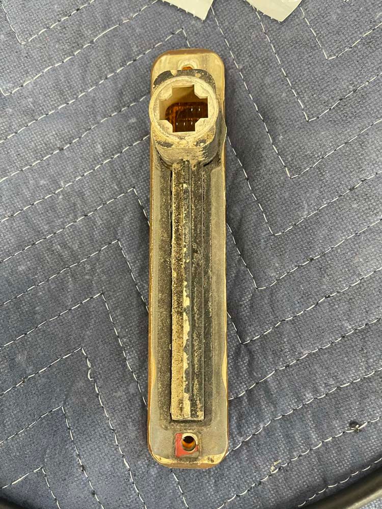 A brass pipe is sitting on top of a blue blanket on a table.