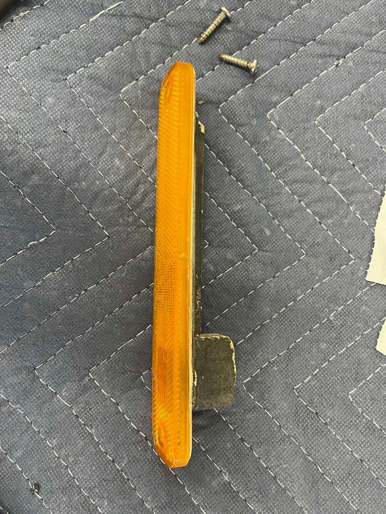 A yellow light is sitting on top of a blue quilt.