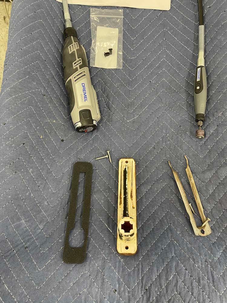 A dremel tool is sitting on top of a blue blanket.