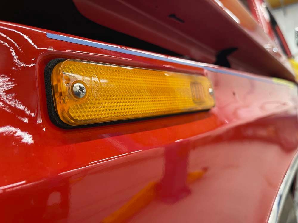A close up of a red car 's side light