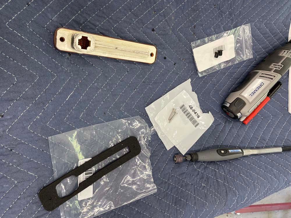 A bunch of tools laying on a table including a dremel