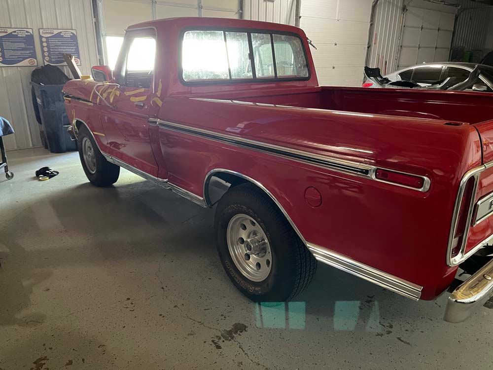 A red pickup truck is parked in a garage.