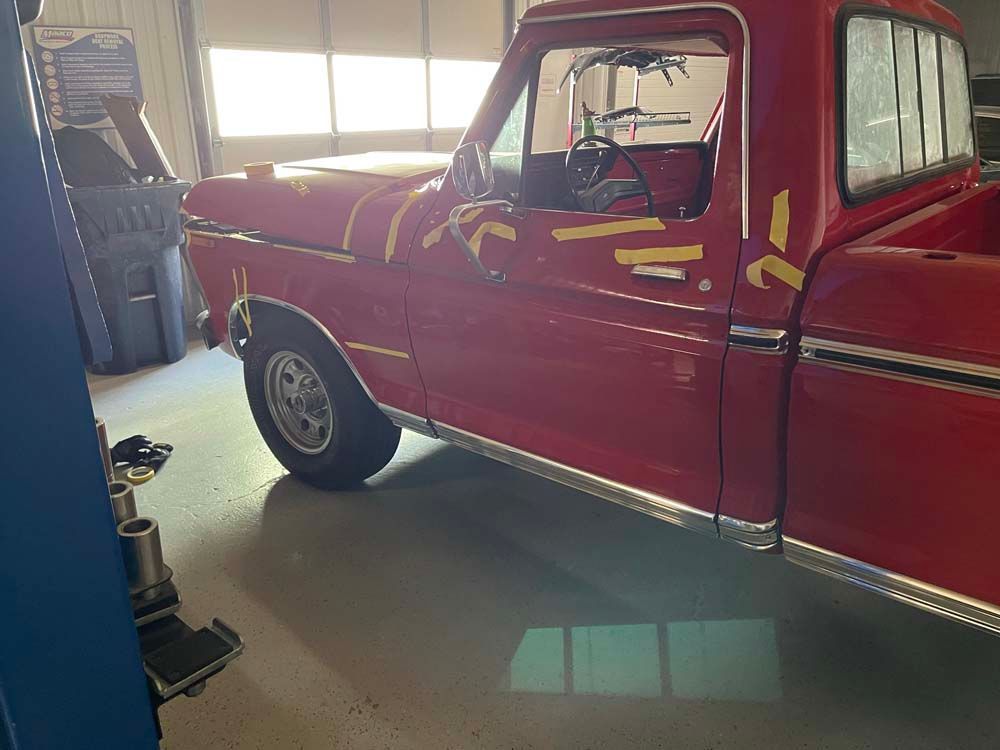 A red pickup truck is parked in a garage.