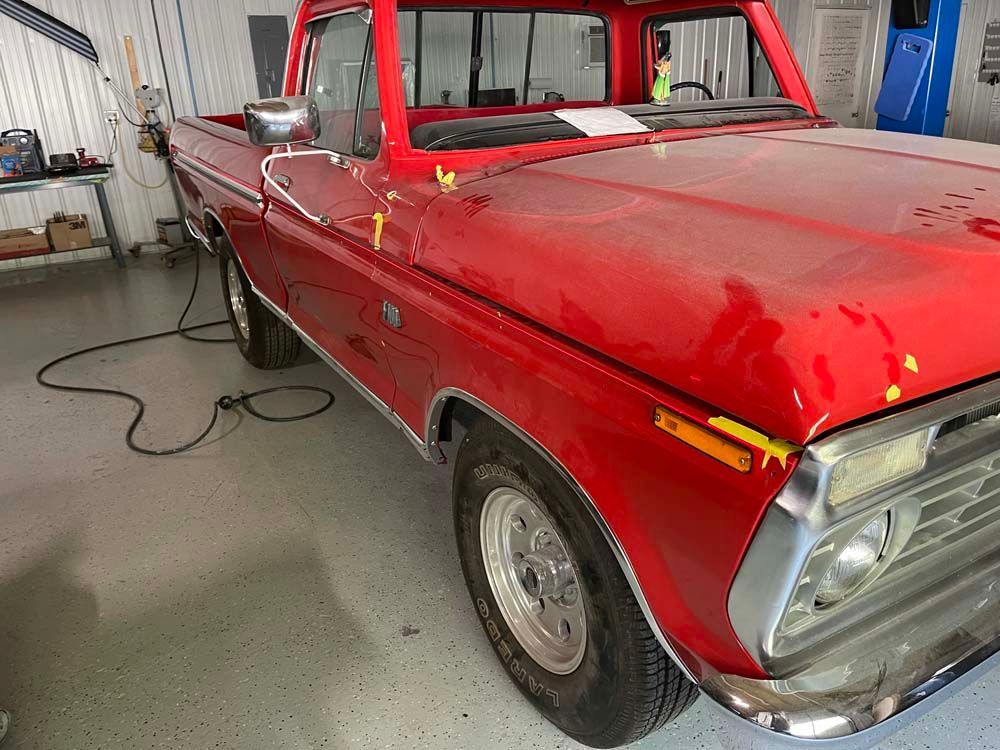 A red pickup truck is parked in a garage.