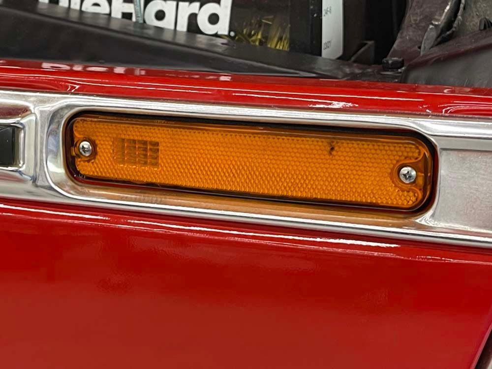 A close up of a bumper light on a red car.