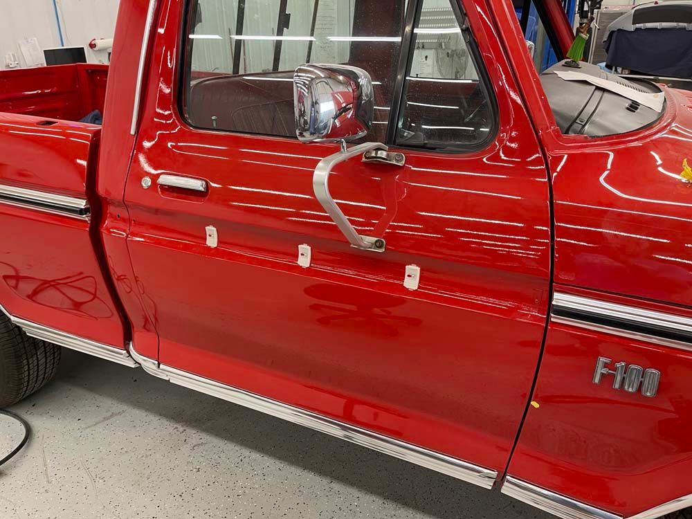 A red ford truck is parked in a garage.