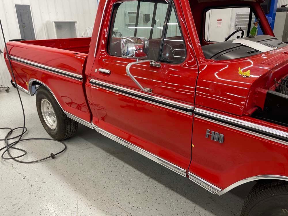 A red ford truck is parked in a garage.