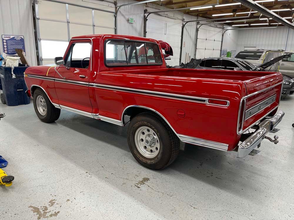 A red pickup truck is parked in a garage.