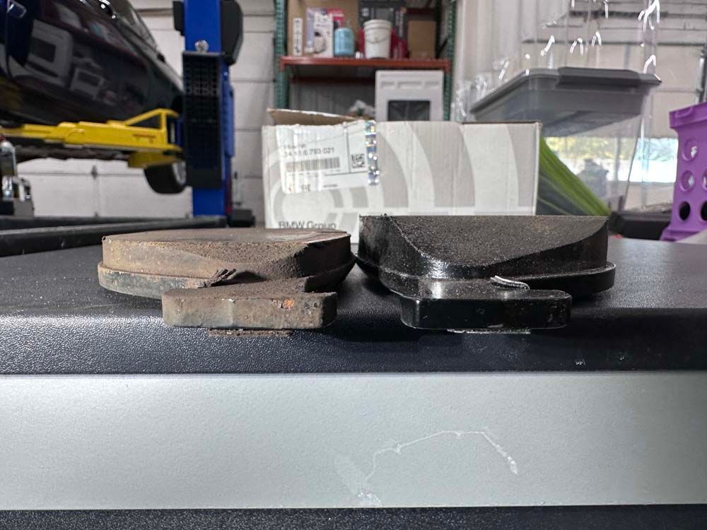 Two brake pads are sitting on a table next to a box.