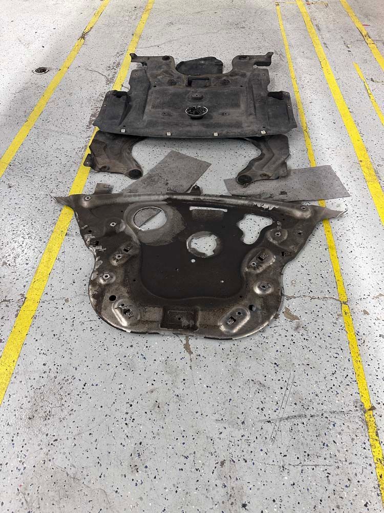 A bunch of pieces of metal are laying on a concrete floor.