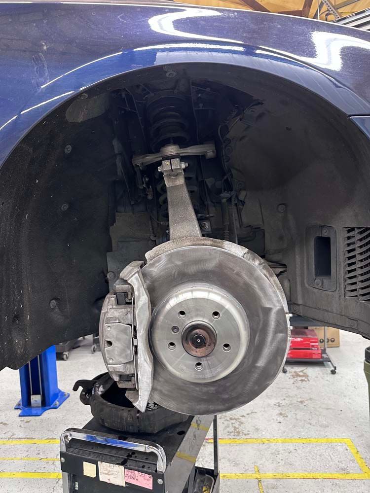 A car wheel is sitting on top of a lift in a garage.