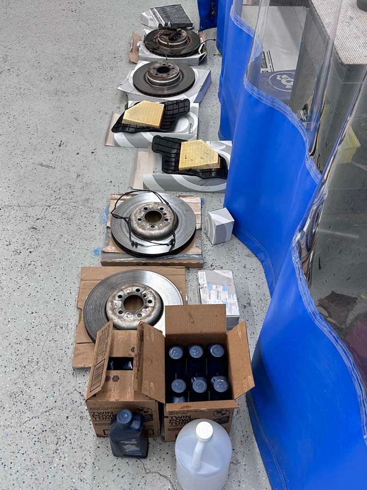 A row of brake rotors sitting on top of a concrete floor next to a blue wall.