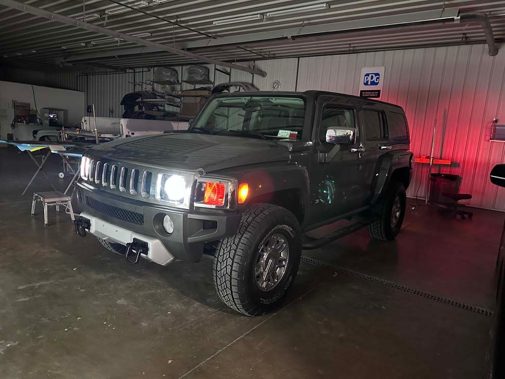 A hummer h3 is parked in a garage.