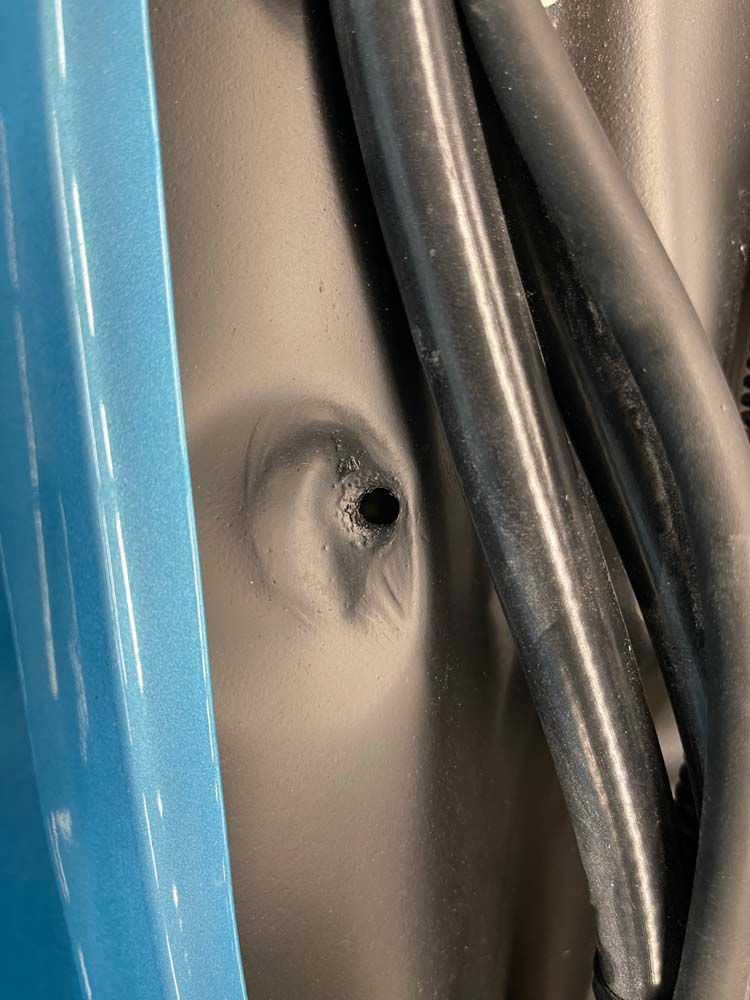 A close up of a hole in the side of a car.