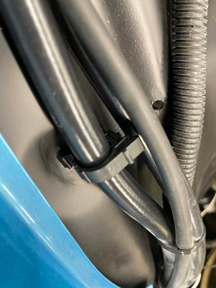 A close up of a hose attached to the side of a car.