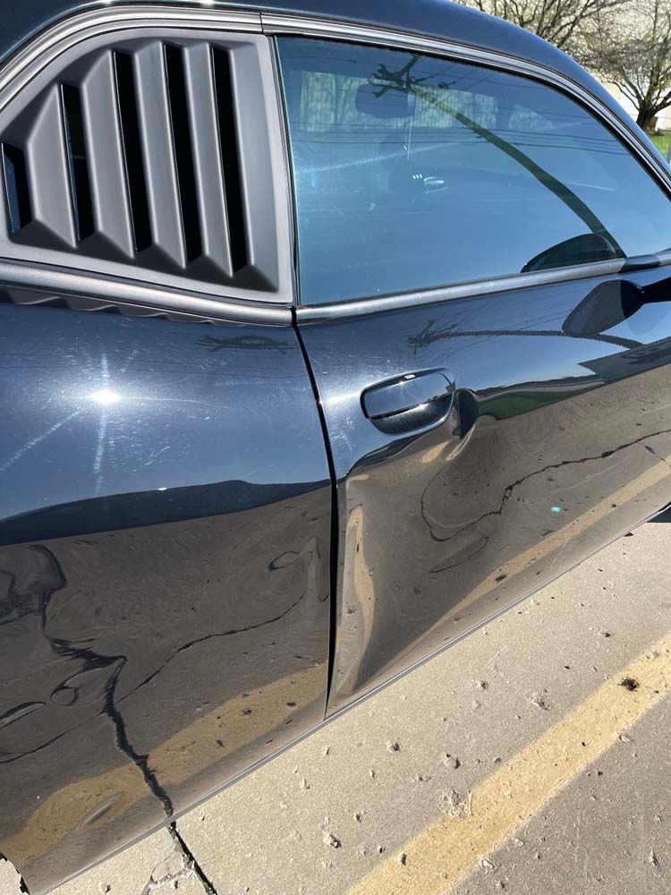 A black car is parked in a parking lot.