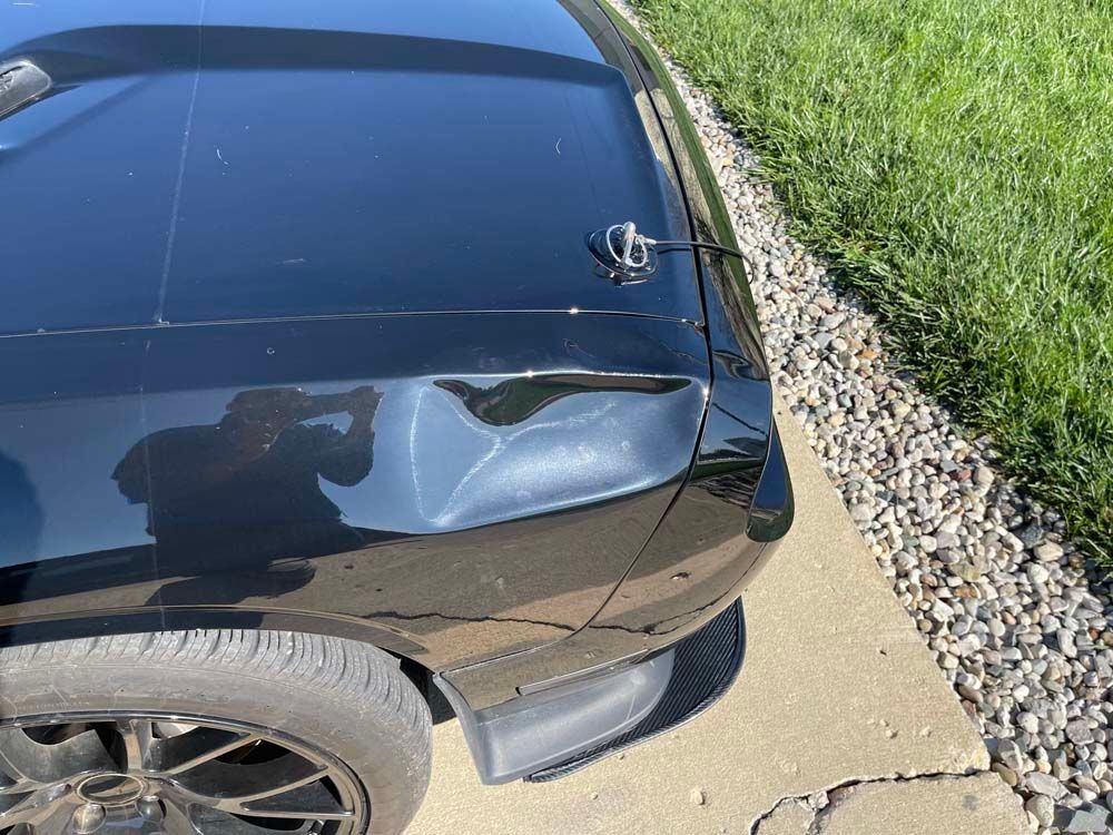 A black car is parked on the side of the road.