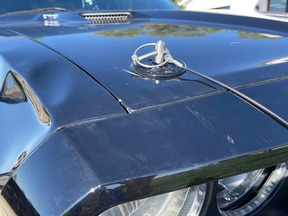 The hood of a black car with a mercedes logo on it
