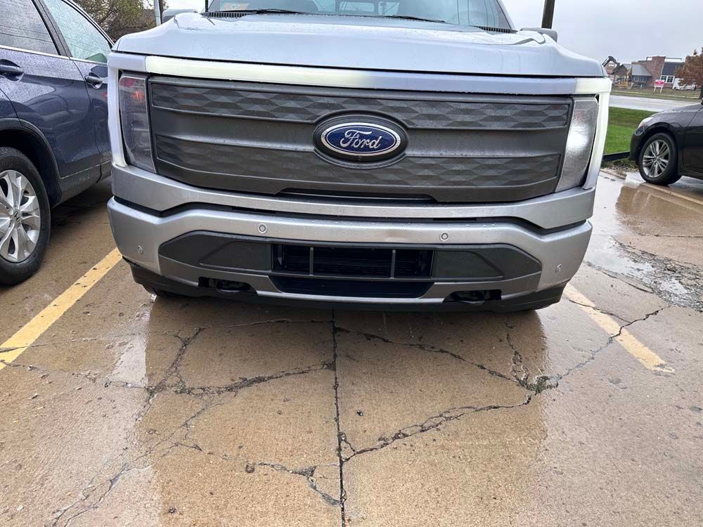 A ford f150 lightning is parked in a parking lot.