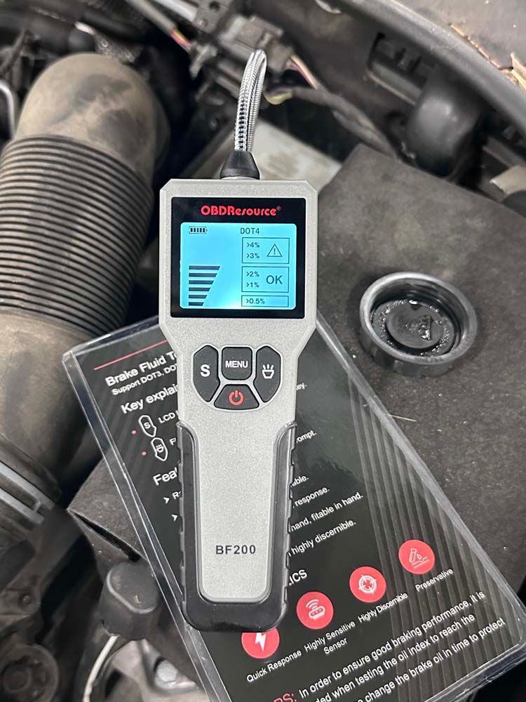 A remote control is sitting on top of a car engine.