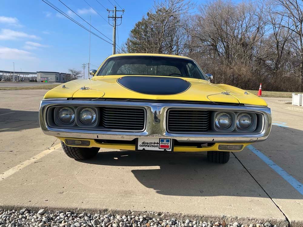 A yellow dodge charger is parked in a parking lot.