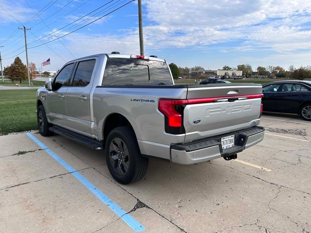 A silver pickup truck is parked in a parking lot.