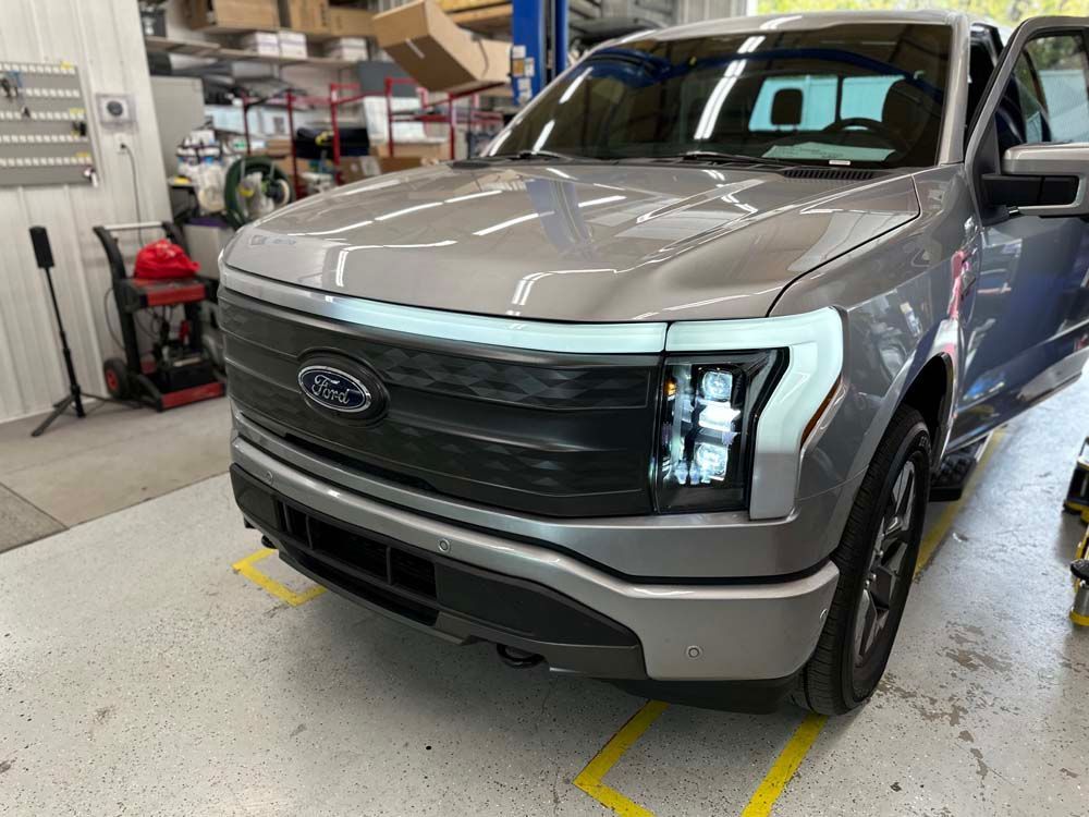 A ford f150 electric truck is being built in a factory.