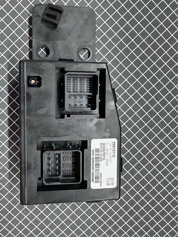 A black electronic device is sitting on top of a checkered table.