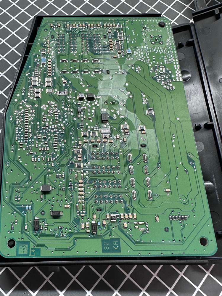A green motherboard is sitting on top of a checkered table.