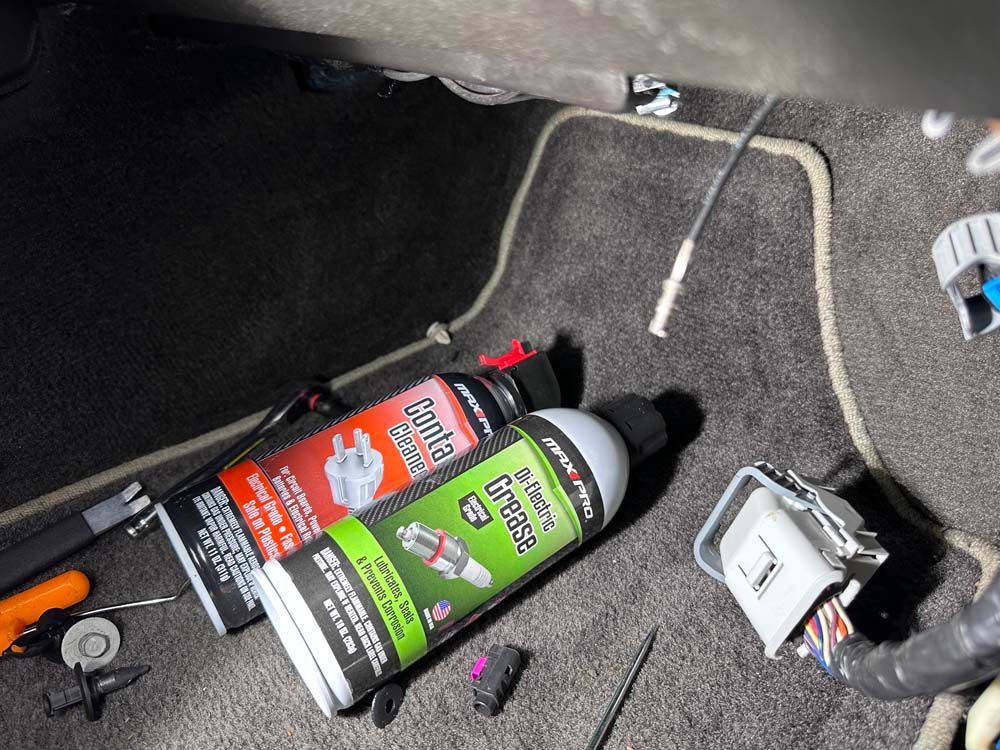 A couple of spray bottles laying on the floor of a car