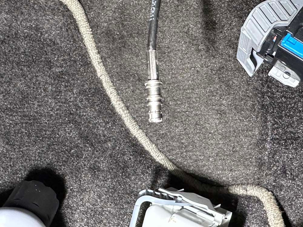 A close up of a cord and a watch on a carpet.