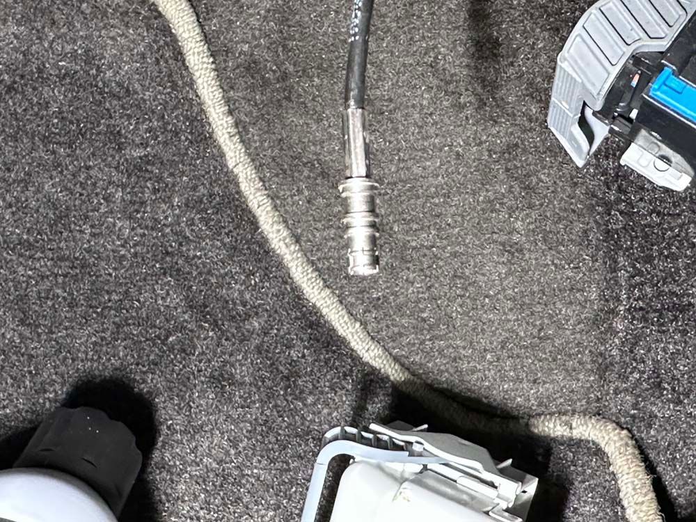 A close up of a screwdriver and a cable on a carpet.