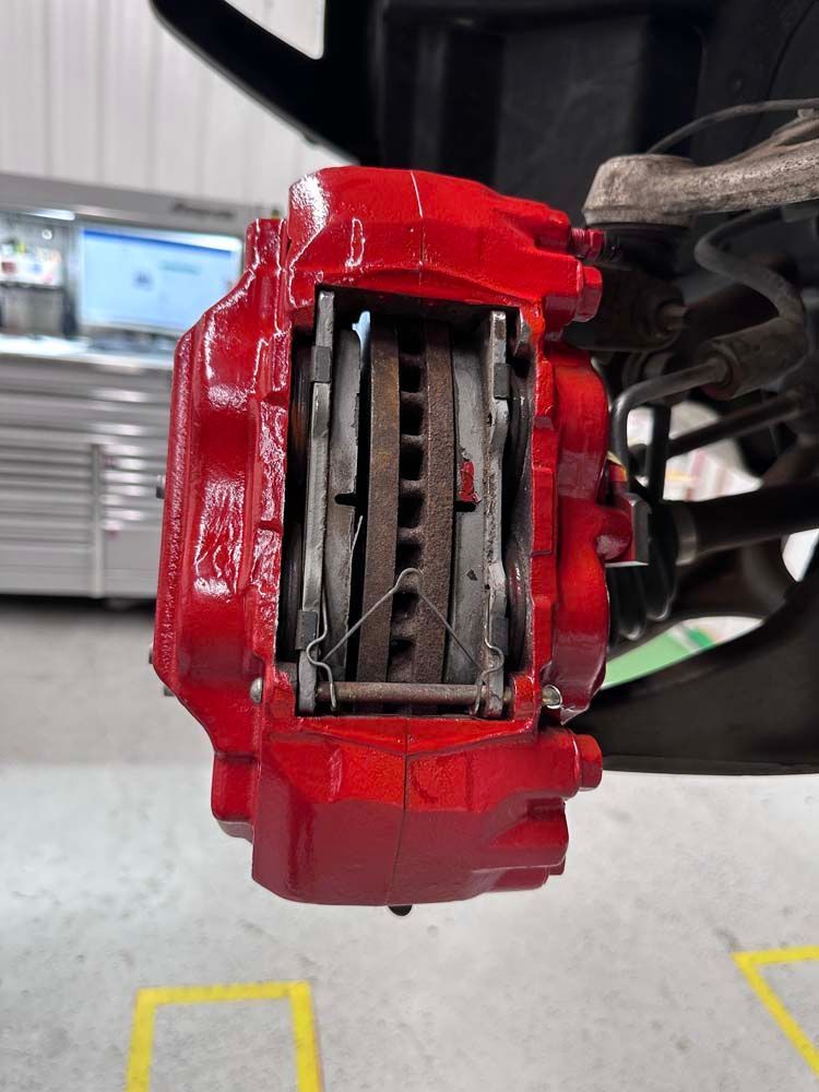 A close up of a red brake caliper on a car