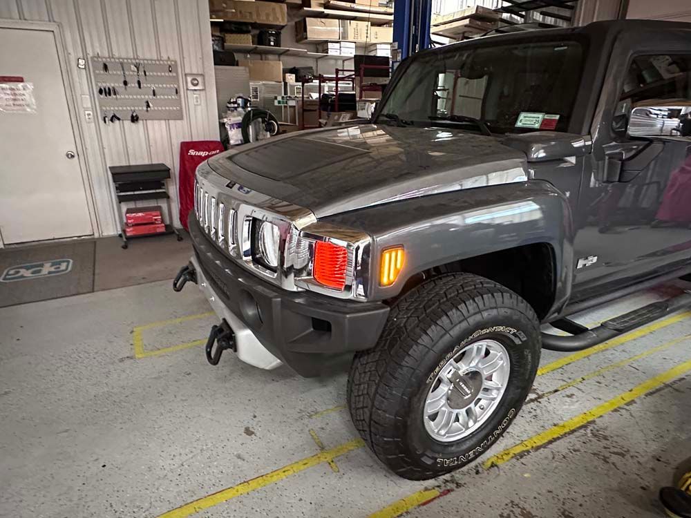 A hummer h3 is parked in a garage.