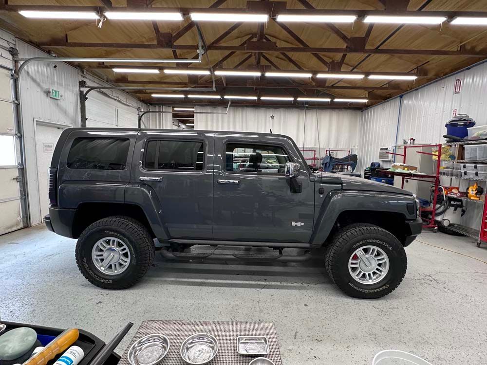 A hummer h3 is parked in a garage.