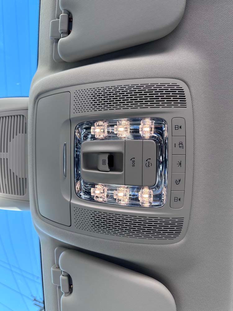 A close up of the ceiling of a car with a blue sky in the background.