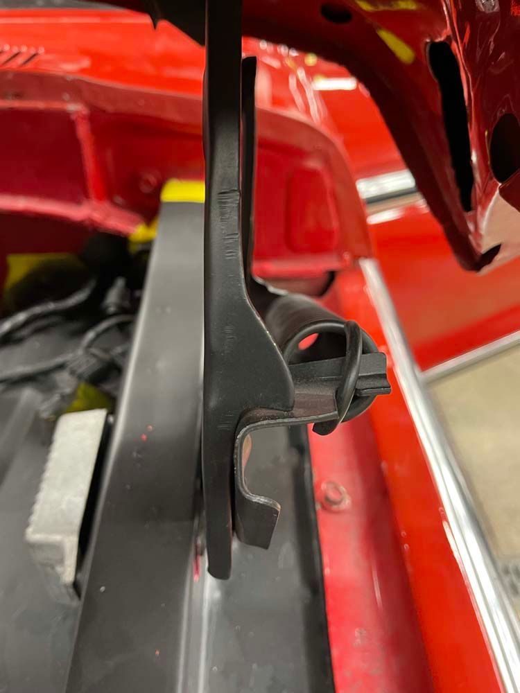 A close up of a red car with the hood open.