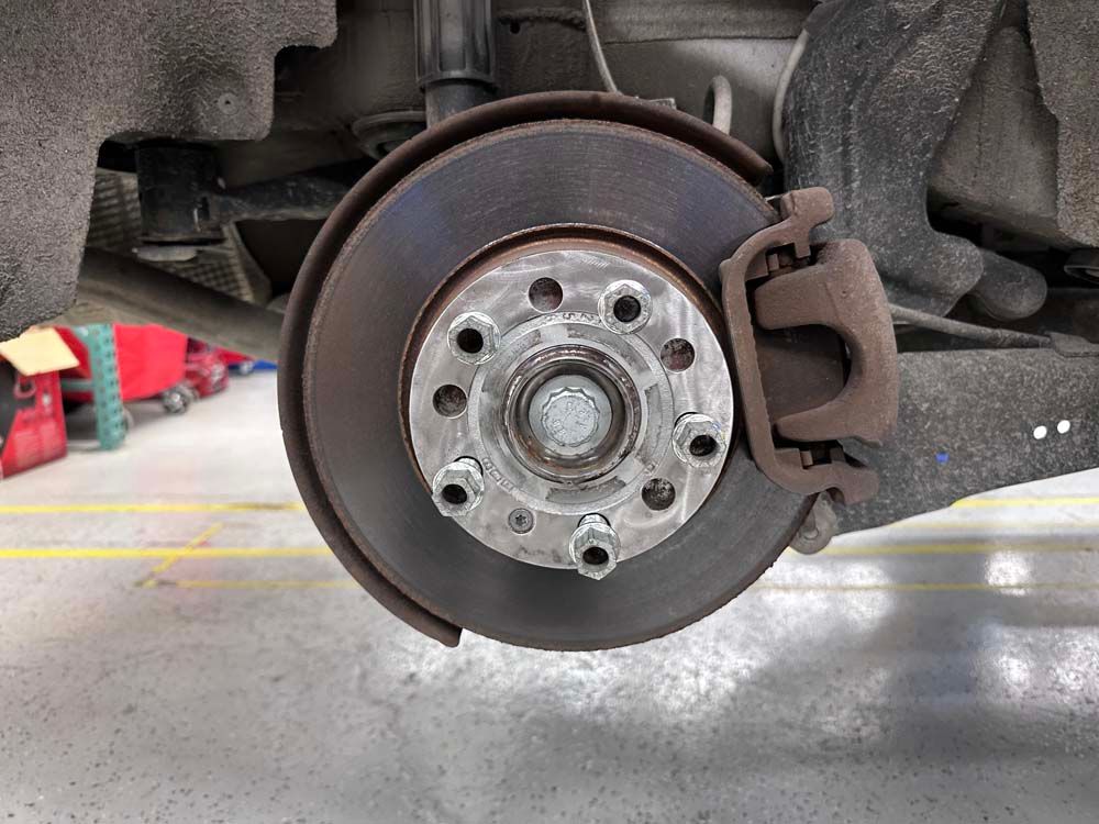 A close up of a car 's brake disc in a garage.