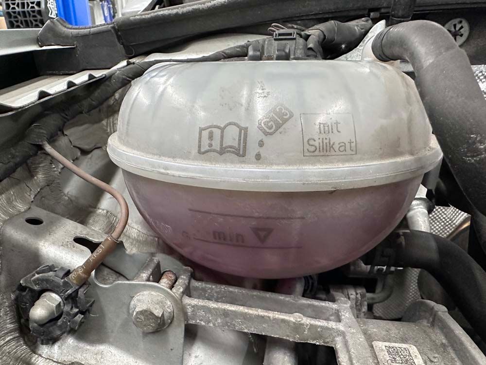 A close up of a water tank in a car engine.