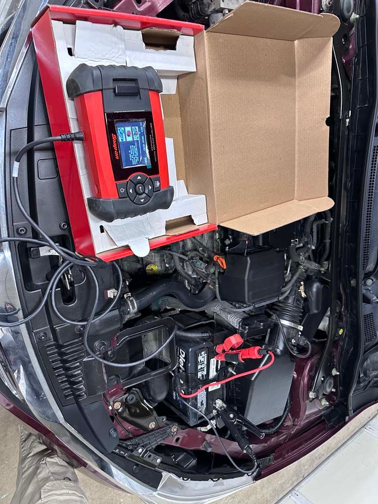 A box is sitting on top of a car engine.