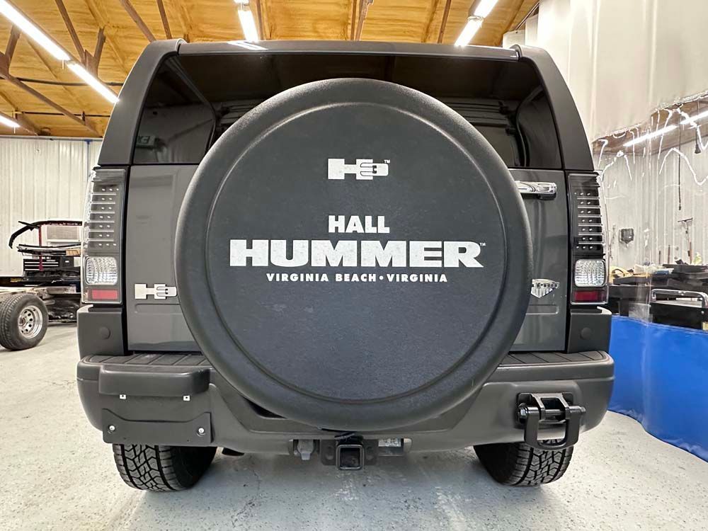 A black hummer is parked in a garage.