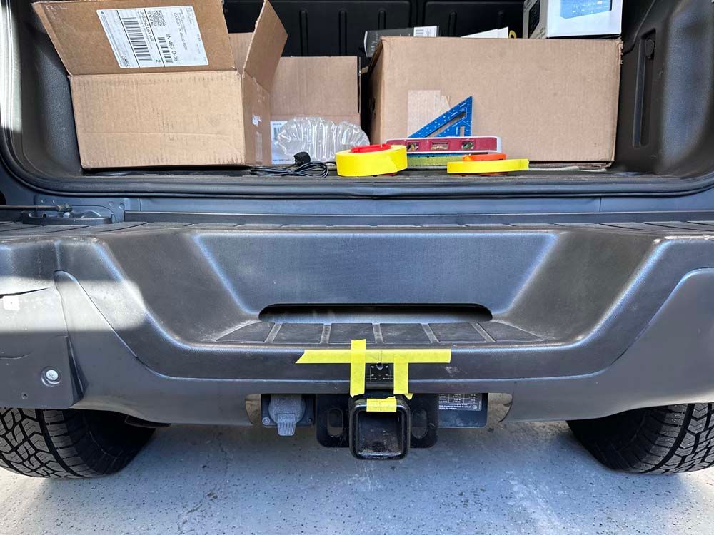 A rear bumper of a car with boxes in the back.