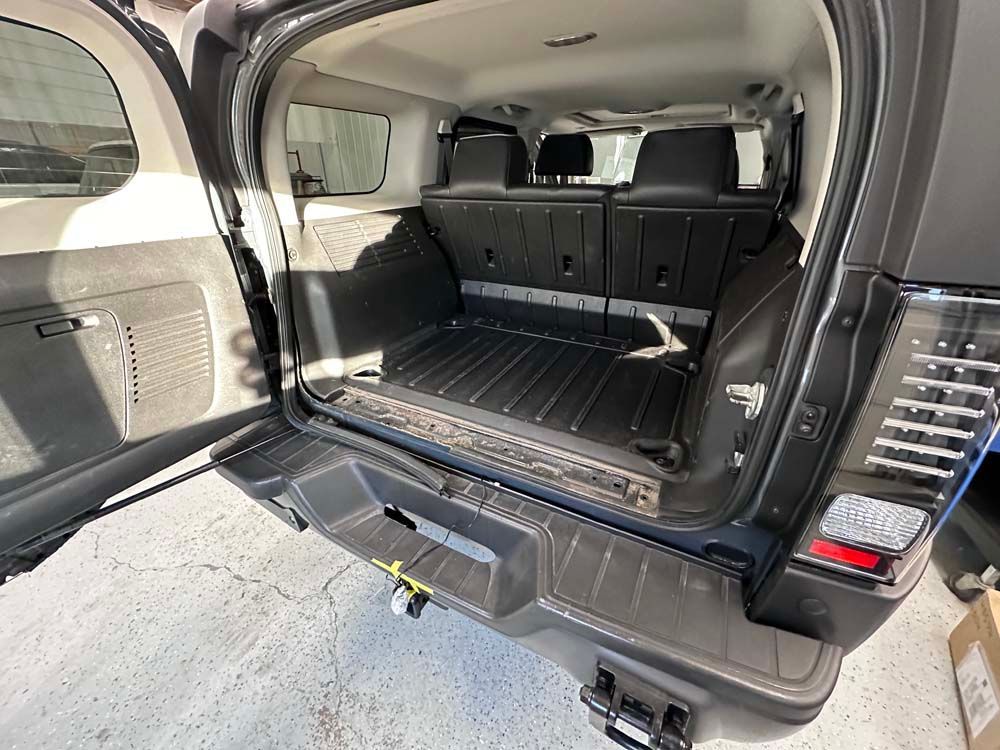 The trunk of a jeep wrangler is open and empty.