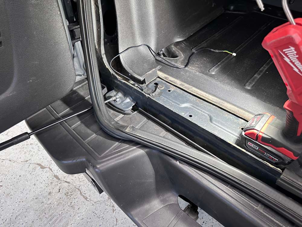 A red milwaukee tool is sitting in the trunk of a car.