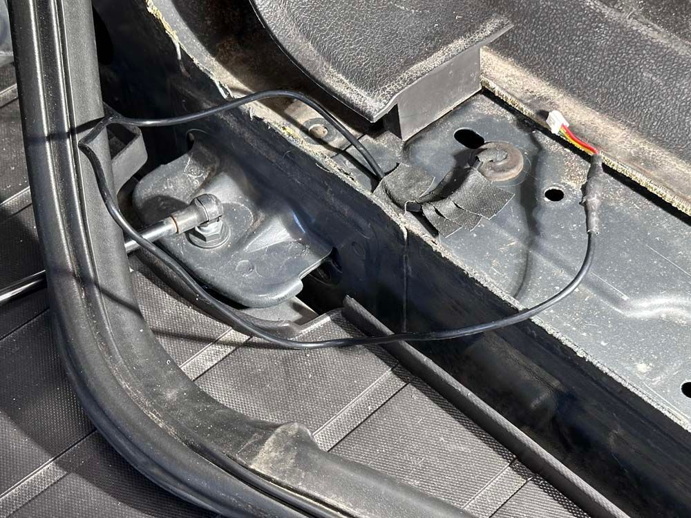 A close up of a car with a wire coming out of it.