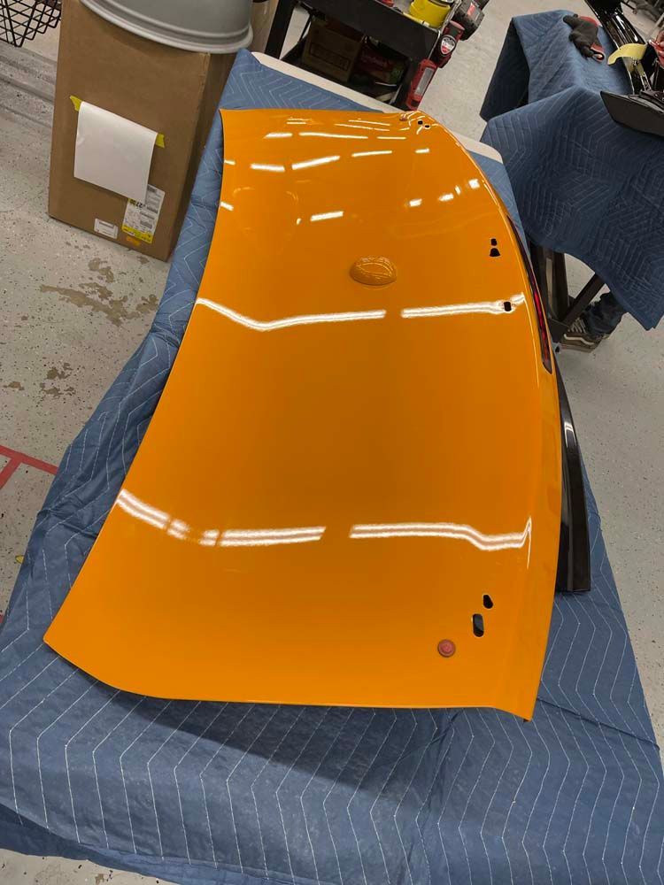 A large orange piece of plastic is sitting on a blue cloth on a table.