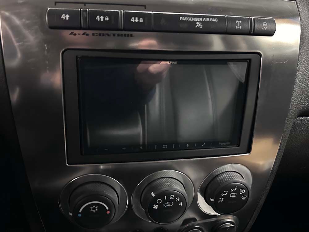 A close up of a car dashboard with a reflection of a person