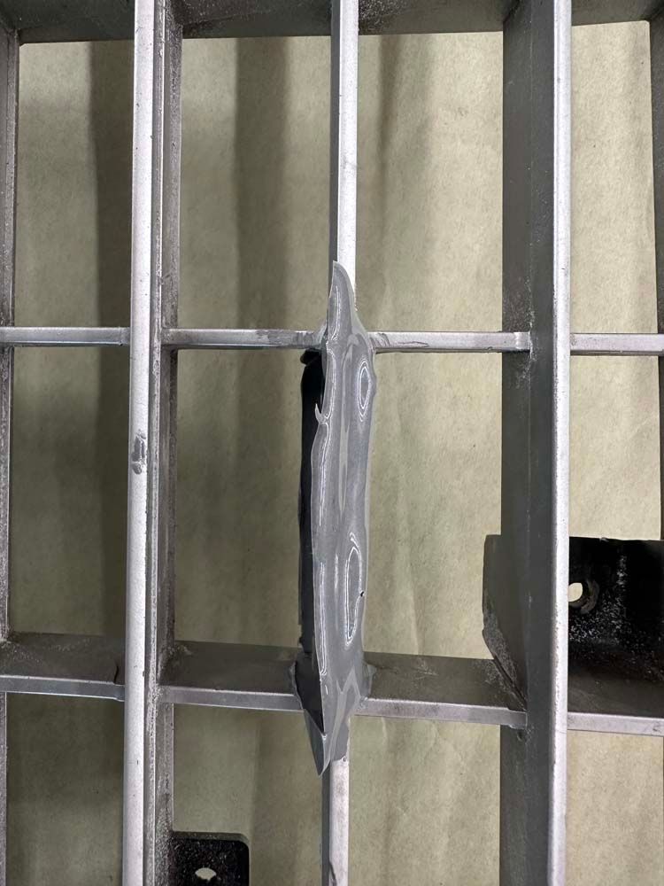 A close up of a metal grate with a hole in it.