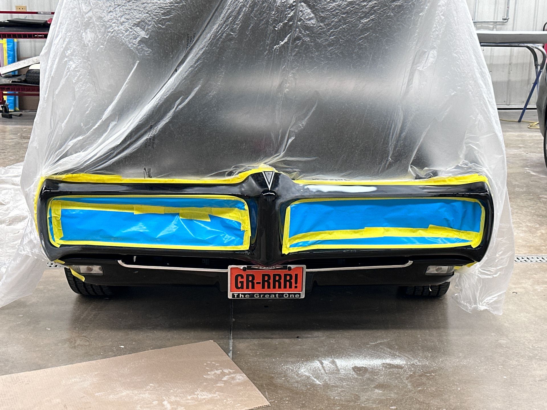 A black car with a license plate that says gr-rrr